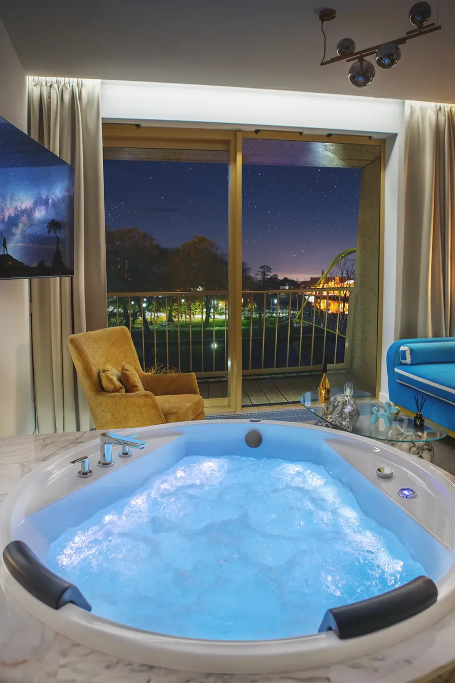 Sypialnia z jacuzzi i nocnym widokiem w Boulevard Residence